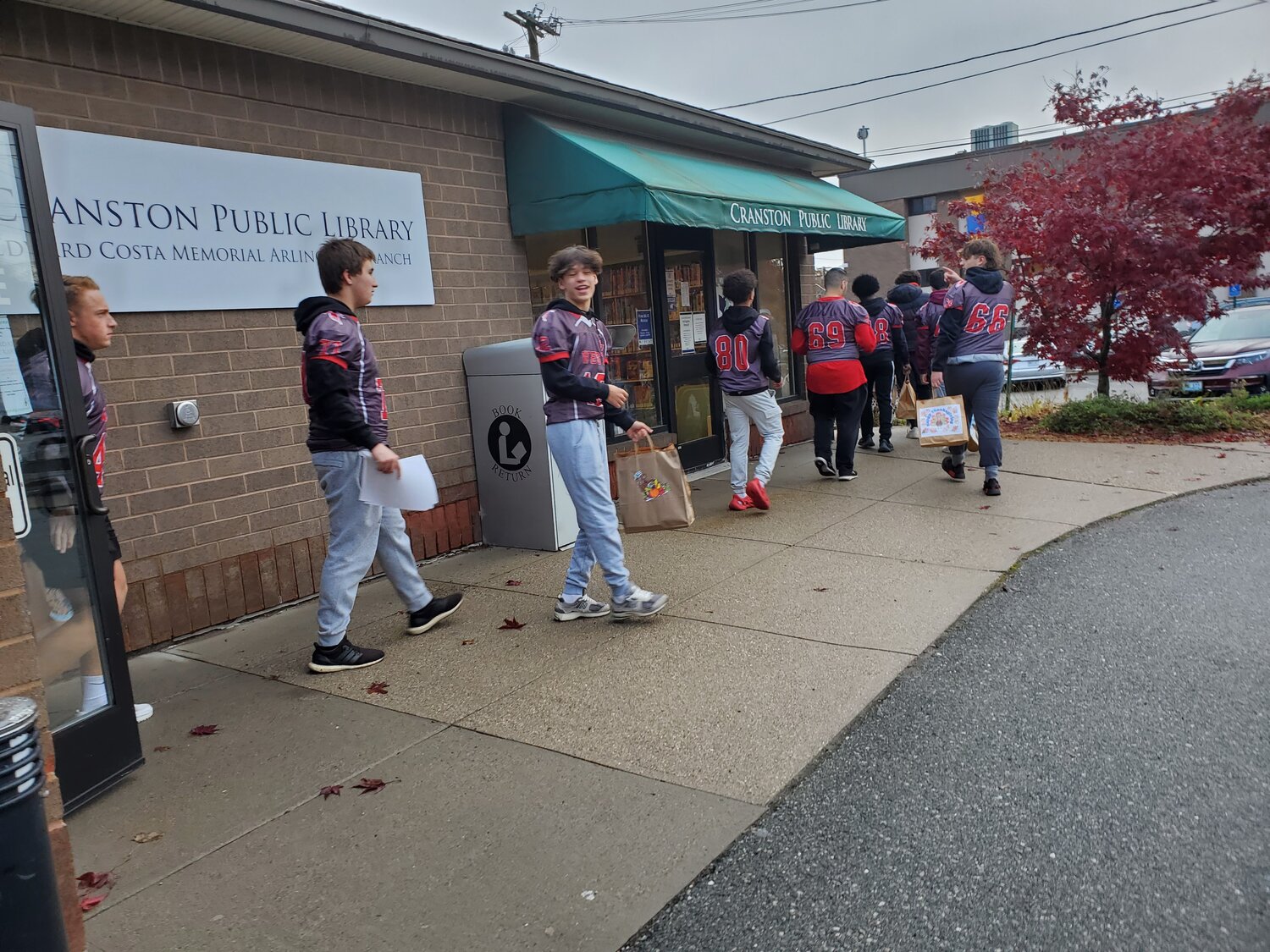 ON THE WAY: Members of Cranston West’s football team head out to make their deliveries.